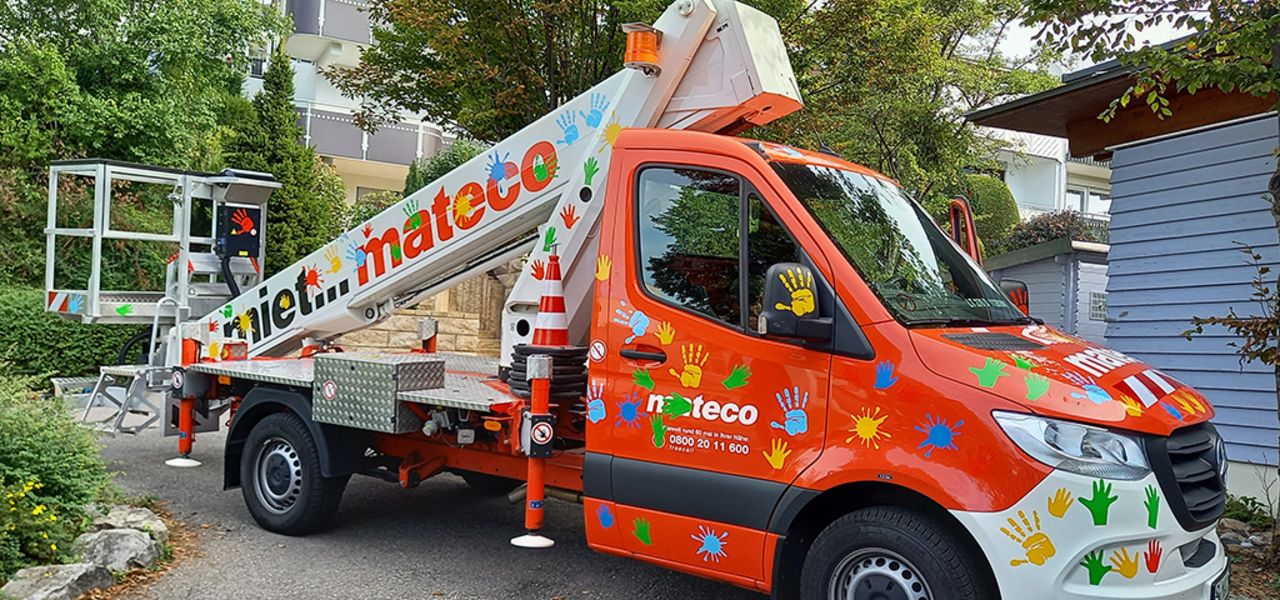 Soziales Engagement: Rote Arbeitsbühne von mateco. Beklebt mit Handabdrücken und Farbklecksen von Kindergartenkindern