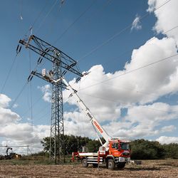 Freileitungsarbeiten mit einem mateco LKW-Arbeitsbühne im Einsatz. Die Arbeitsbühne wird verwendet, um an einer Freileitung in großer Höhe zu arbeiten.