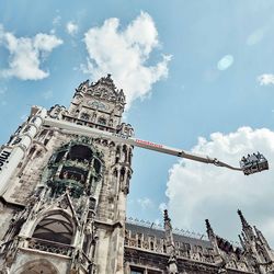 Arbeitsbühne vor einem Gebäude mit drei Arbeitern im Korb