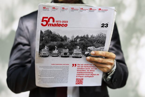 Mann hält Jubiläumszeitung in der Hand
