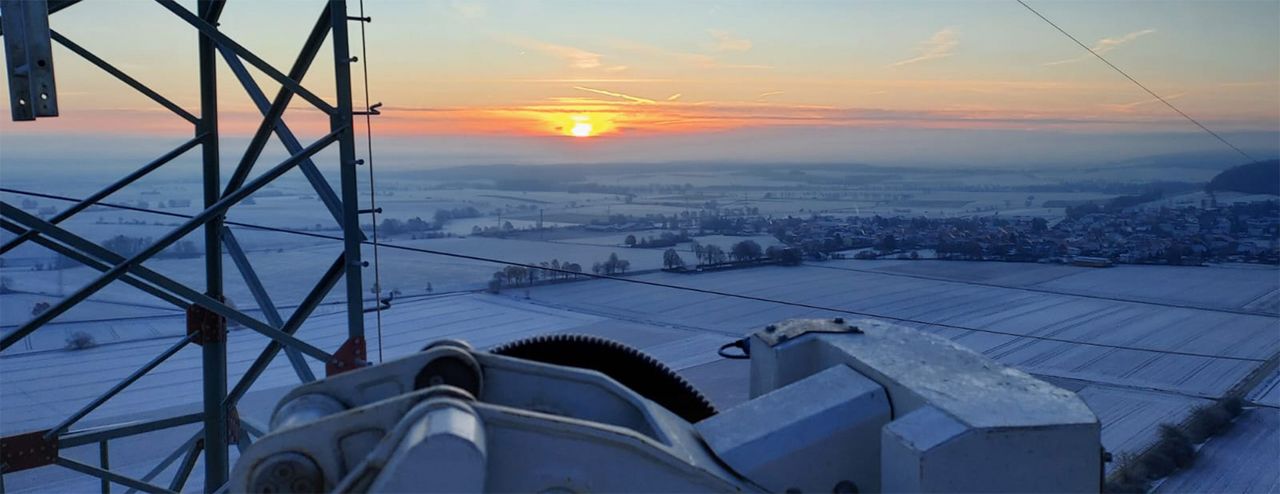 Sonnenaufgang über Feldern im Winter von einer Arbeitsbühne aus.