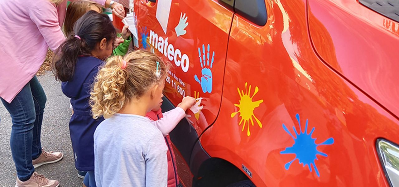Soziales Engagement von mateco: Kindergartenkinder bekleben eine rote Arbeitsbühne