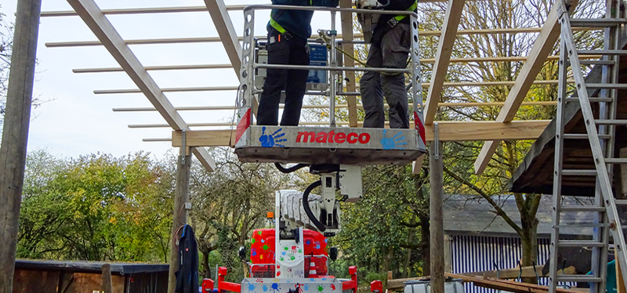 Soziales Engagement von mateco: Zwei Männer mit Bohrmaschine arbeiten an einem Vordach für den Abenteuerspielplatz