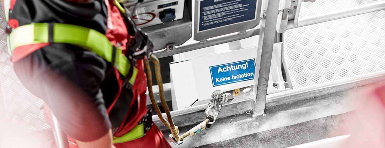 Arbeiter trägt eine PSAgA und befindet sich in einem Korb